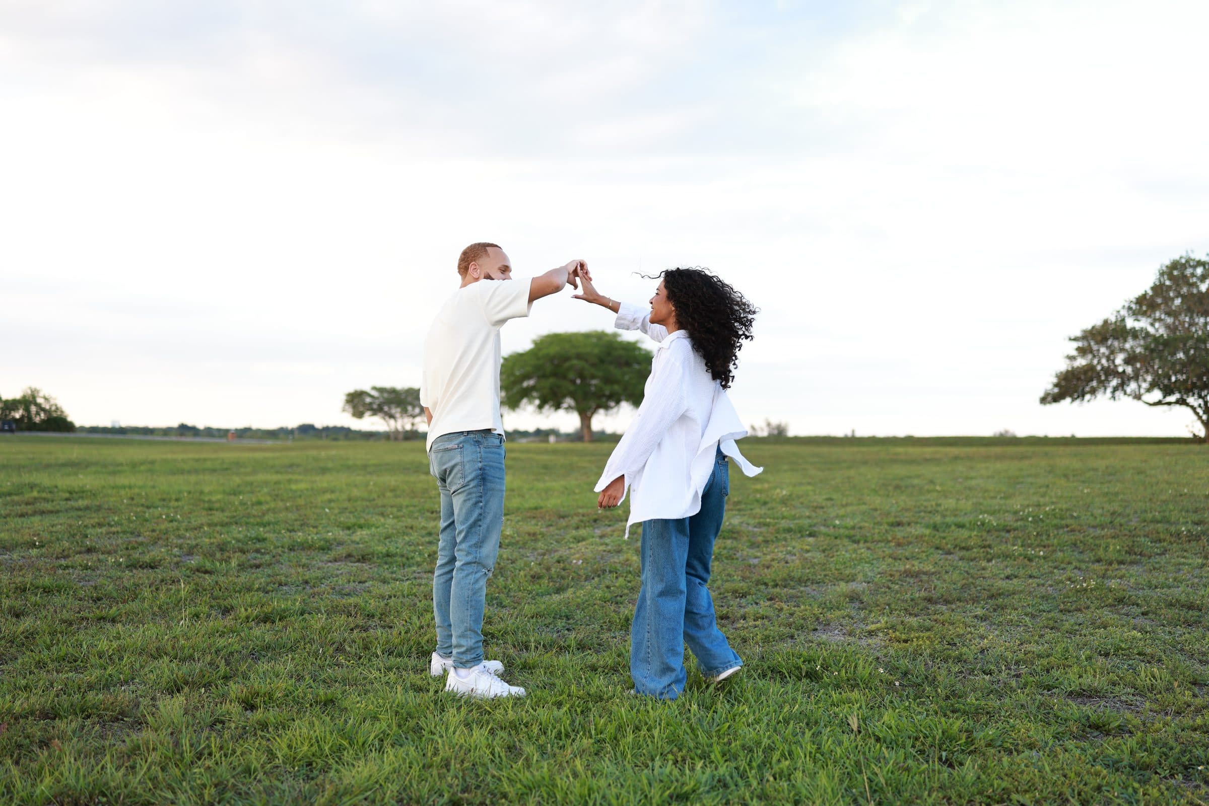 Ray twirling Alexia as they dance together in the open field