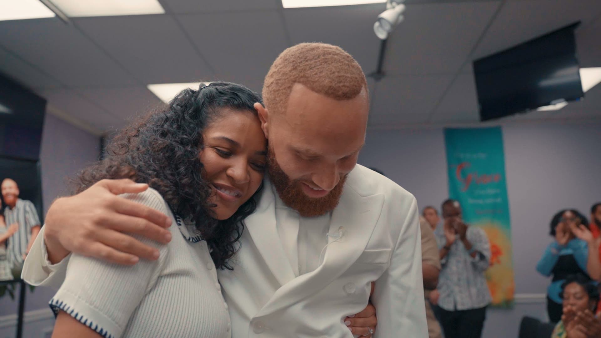 A still from Ray and Alexia's engagement film — the two of them embracing, surrounded by family